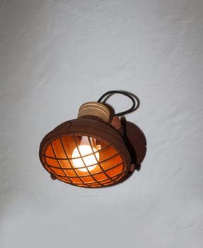 A spotlight-like lamp attached to a house wall.
