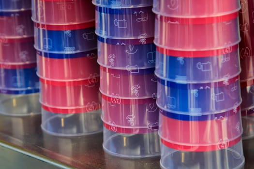 Many stacked colorful printed plastic drinking cups.