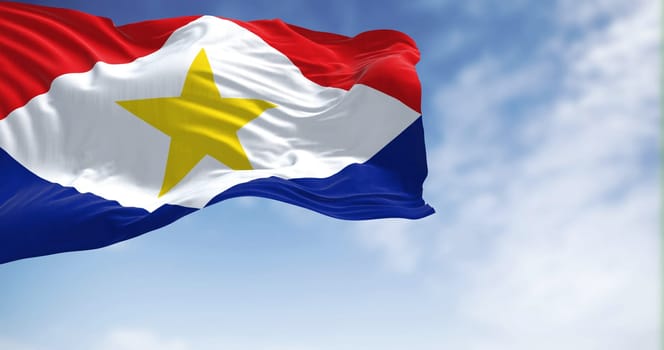 Close-up view of Saba national flag waving in the wind. Saba is the smallest island in the Dutch Caribbean and is a special municipality in the Netherlands. Fabric textured background. Selective focus