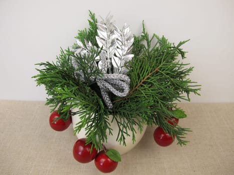 Small handmade christmas arrangement with thuja and decoration in a vase