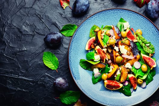 Unusual salad with figs, plums, herbs and olives. Vegetarian salad