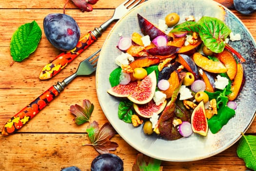 Unusual salad with figs, plums, herbs and olives. Vegetarian salad