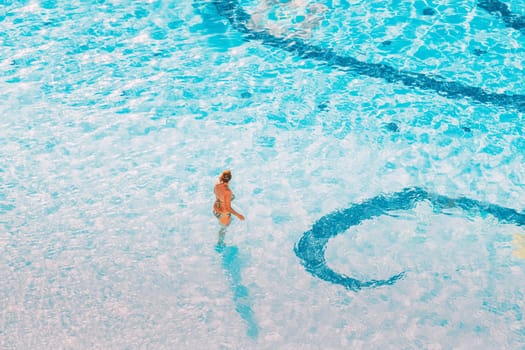 Adult Caucasian Lady Woman Standing In Hotel Swimming Pool In Sunny Summer Day. Vacation In Hotel.