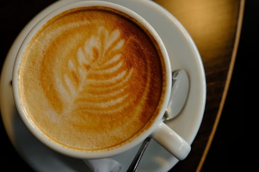 White cup of espresso coffee close up with beautiful tree patern from milk foam in the cup.