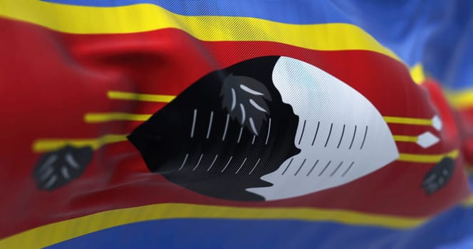 Close-up view of the Eswatini national flag waving in the wind. ESwatini is an independent state of southern Africa, known until 2018 as Swaziland.. Fabric textured background. Selective focus