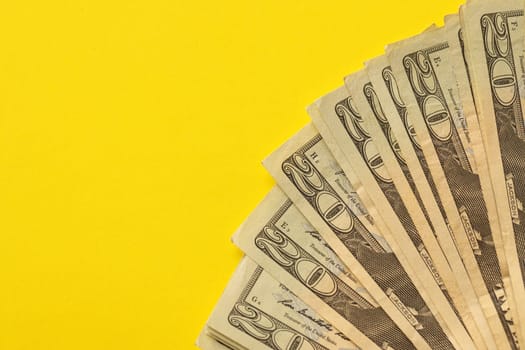 Big amount of old twenty dollar bills on yellow background. Money earnings, payday or tax paying period concept