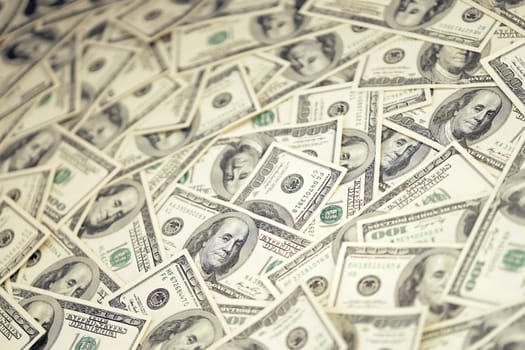 A pile of one hundred US banknotes with president portraits. Cash of hundred dollar bills, dollar background full frame image with high resolution