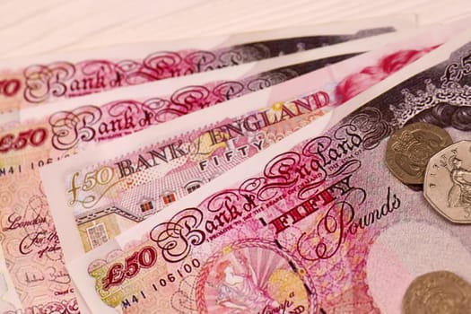 UK money bills and coins close up. Big amount of United Kingdom pounds and small coins on table. Business and stock concept for England