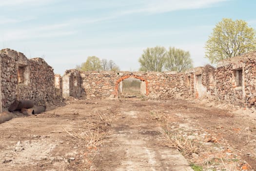 Old partially destroyed building of vintage hangar or warehouse without roof made of large cobblestones for storing corn and other agricultural products
