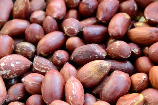 Peanut. A lot of small yellow nuts with brown peel. Background texture