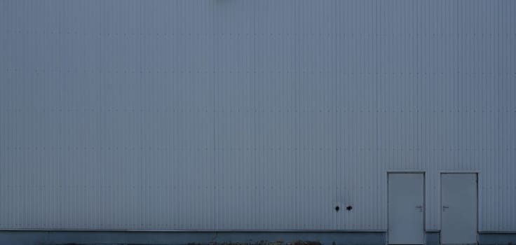 Texture of a high metal wall of an industrial building without windows