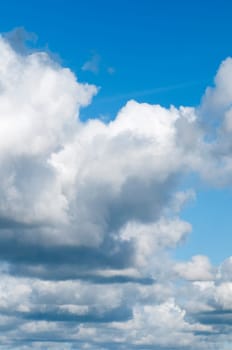 Full frame view of gathering clouds with clear space overhead and blue sky.