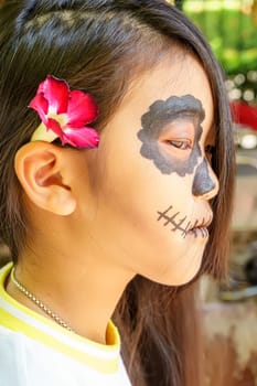 Close up the attractive girl in the sugar skull makeup. Day of The Dead. Halloween.