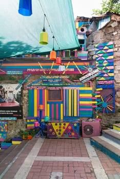 Exterior daytime shot of stone cafe decorated with multicolored panels colorful stairs, and canopy in Balat District, Istanbul, Turkey