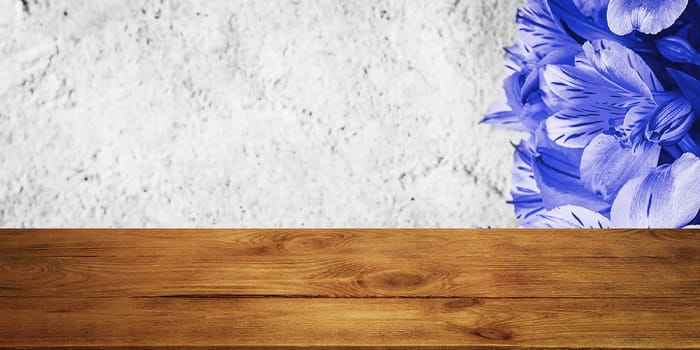 Background flowers on a textured stucco wall and blank wooden planks in the foreground. For product demonstrations, free space, layout, mockup, perspective board, background board.