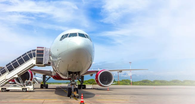 The Airplane with a passenger boarding steps on the airport apron