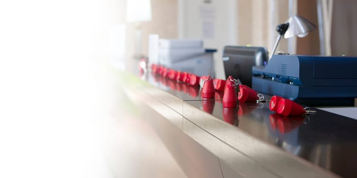 The hotel receptionist with red keys on sun light. Selective focus