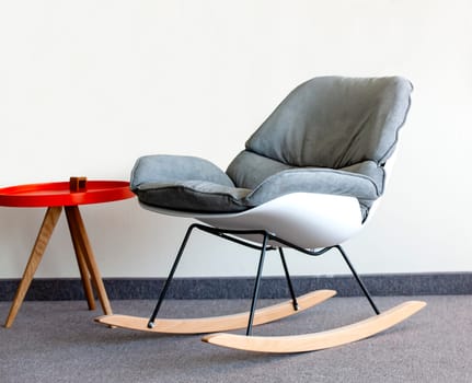 The rocking chair and  table against the wall. Interior inside