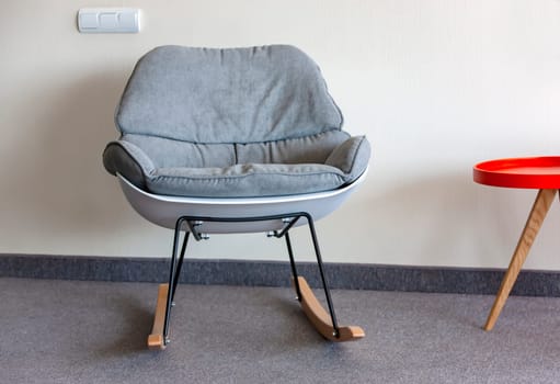 The rocking chair and  table against the wall. Interior inside. Selective focus