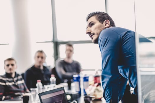 Businessman making a presentation at office. Business executive delivering a presentation to his colleagues during meeting or in-house business training, explaining business plans to his employees.