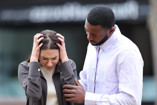Good black man comforting his sad friend outdoors