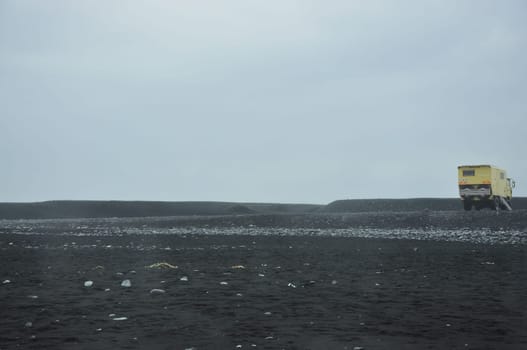 Overlander motorhome captured in a black sand beach