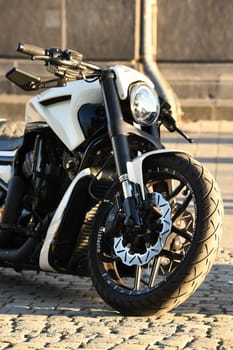 Vertical closeup of a white chopper motorcycle parked under the sunlight. Harley Davidon in Duesseldorf, Germany.