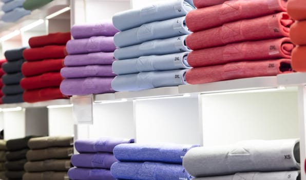 Polo t-shirt store interior. Shop shelves with  colored fashion cotton shirts.