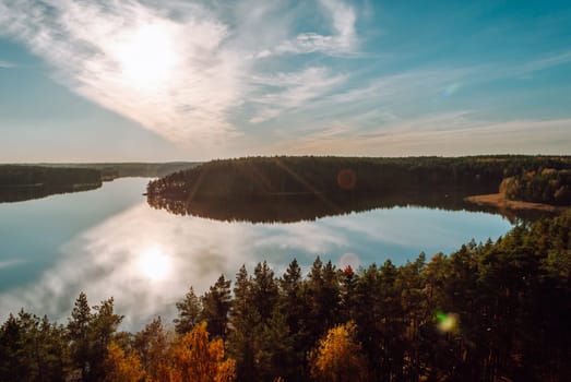 View from the observation tower in the evening of Lake Baltieji Lakajai in Labanoras Regional Park, Lithuania. Evening light, blue sky with taxations and forest