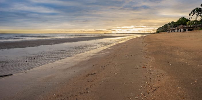 Sunrise on a stormy morning over Pialba, Hervey Bay Queensland, at low tide showing a sandy foreshore. This is a very popular tourist destination.