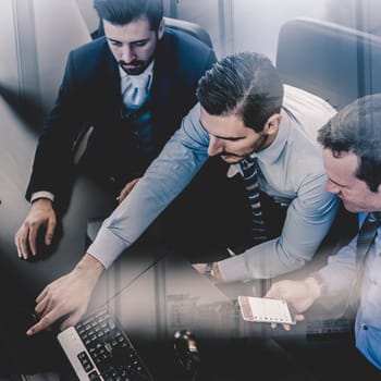 Businessmen trading stocks. Stock traders looking at graphs, indexes and numbers on multiple computer screens. Colleagues in discussion in traders office. Business success concept.