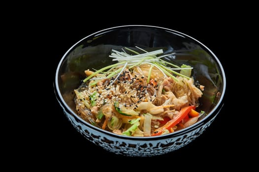 Harusame noodles with seafood in a deep bowl on a black isolated background. High quality photo