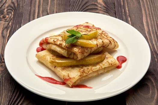 delicious juicy pancakes drizzled with sauce are served on a white plate. High quality photo