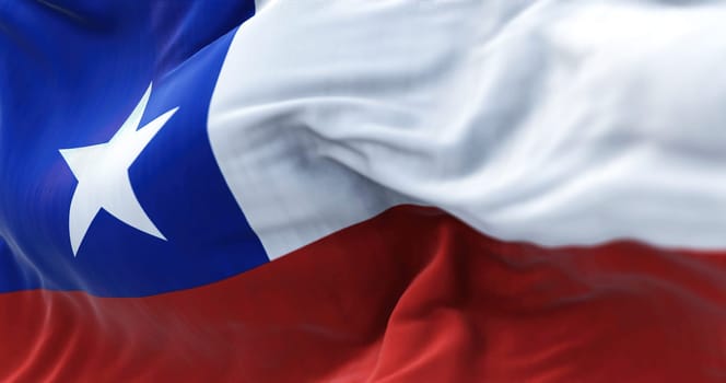 Close-up view of the Chile national flag waving in the wind. The Republic of Chile is a country in the western part of South America. Fabric textured background. Selective focus