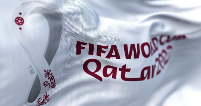 Doha, QA, October 2022. Close-up view of the FIFA Qatar 2022 World Cup flag waving in the wind. The World Cup will take place in Qatar from 20 November to 18 December 2022