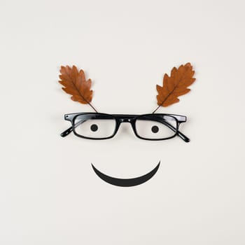 Head with a smiling face, eyeglasses and foliage, mental health concept, positive mindset, support and evaluation symbol