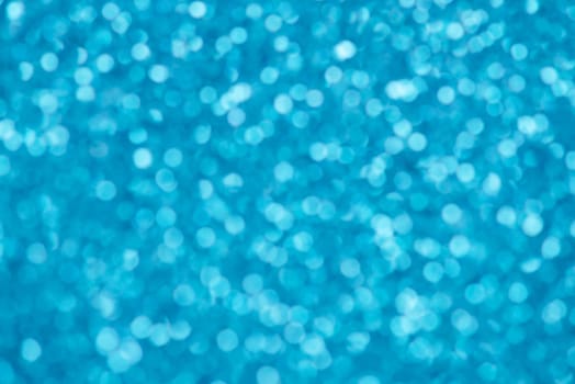 Blue bokeh background for christmas, defocused round lights and sunbeams, flare overlay