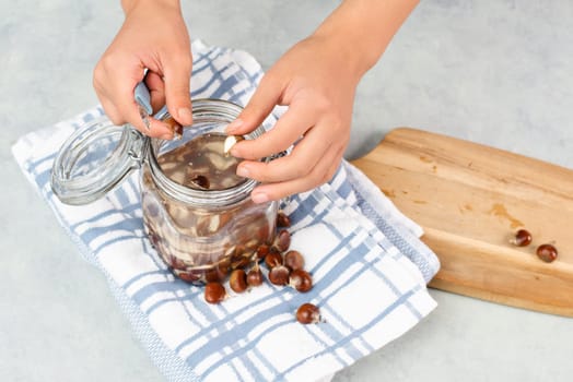 Preparing chestnut liquid soap, cutting buckeye and putting it into a jar with water, alternative homemade detergent for washing clothes