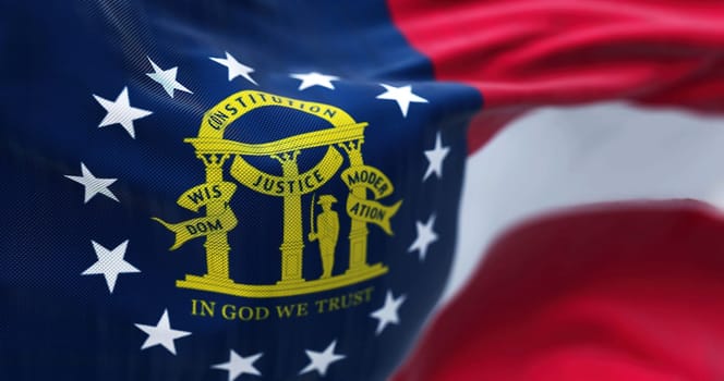 Close-up view of the Georgia state flag waving in the wind. Georgia is a federated state of the United States of America. Fabric textured background. Selective focus