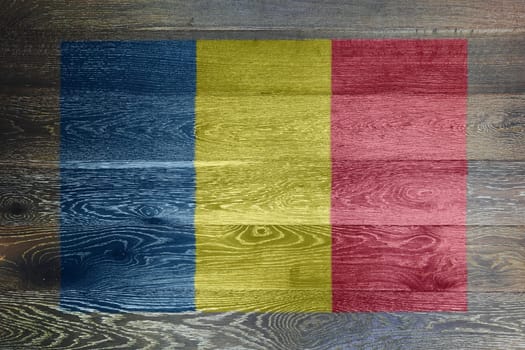 A Romania flag on rustic old wood surface background blue yellow red