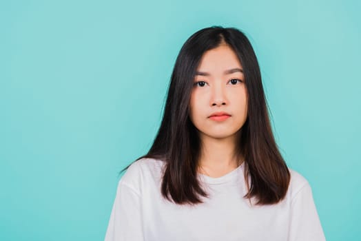 Close up face of Asian beautiful young woman, portrait of happy Thai female confident smiling looking to camera, studio shot isolated on blue background