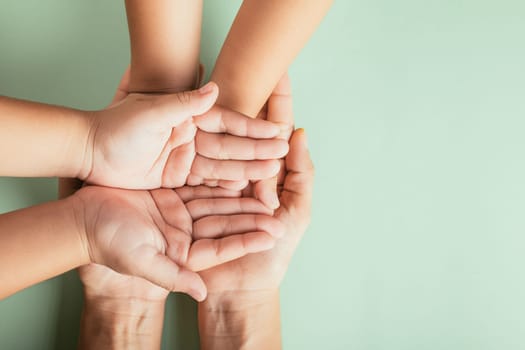 Close up hands children on adult mother hand, Top view person kid stack mom palms, Parents and little kid holding empty hands together isolated on green background, Family day care concept