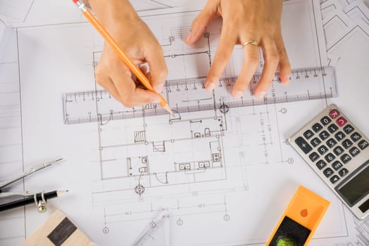 Architectural project workplace. Architect drawing with ruler on house plan blueprint paper for repair tools on table desk at architecture office, architect sketching construction, Engineering tools