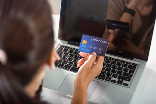 Female register via credit cards on computer make electronic payment security online, Woman hands holding credit card and using laptop with product purchase at home, Internet online shopping concept