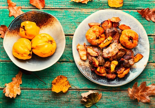 Appetizing pork stew with quince in tray. Autumn recipe