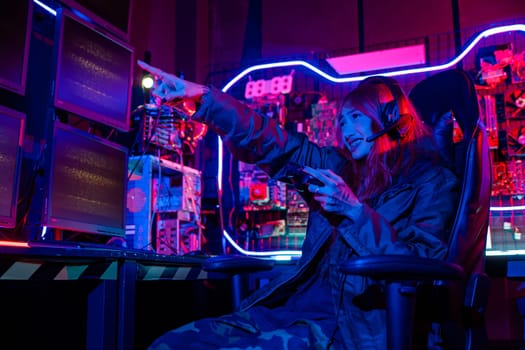 Woman wear gaming headphones playing esports games console gaming room, Gamer using joystick controller for race tournament plays online video game with computer neon lights