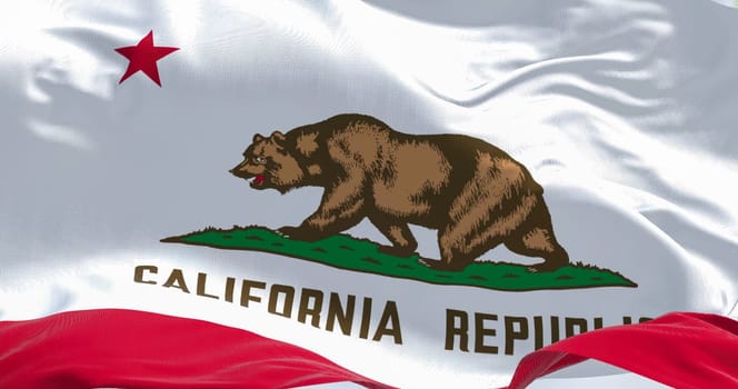 Close-up view of the California State flag waving in the wind. California is a federated state of the US located in the South West Coast. Fabric textured background. Selective focus