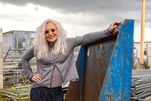 Stylish Lady with long curly hair surround industry area.