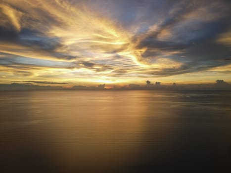 Aerial dramatic orange cloud sunset reflection at sea
