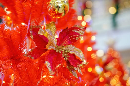 Christmas red flower and bell at red tree with led background. Winter holiday concept